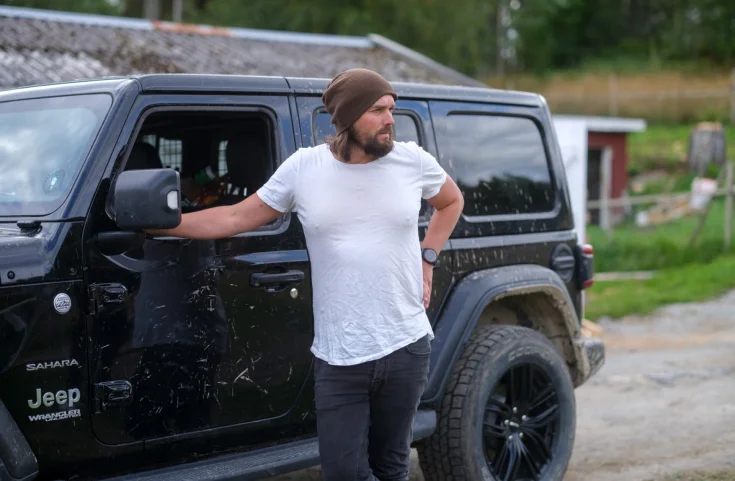 Henrik framför sin jeep hemma på gården